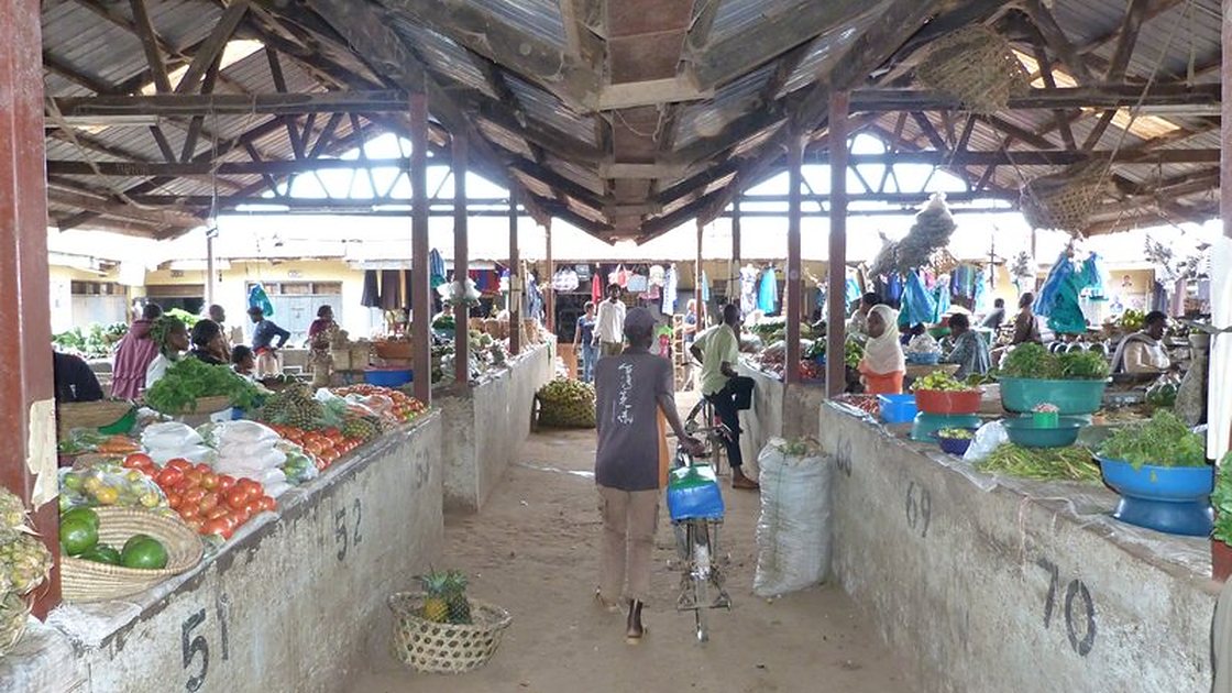 Covered aisle of produce stalls at Kabale Main Market, Uganda